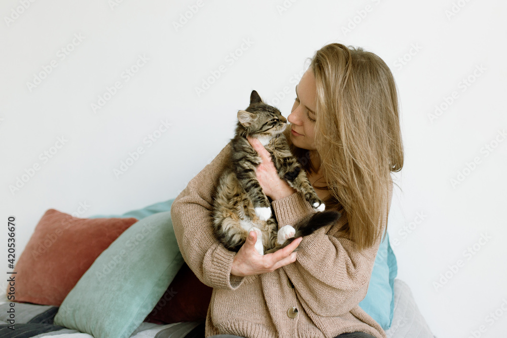 Attractive young woman playing with her cat at home Attractive young woman playing with her cat at home