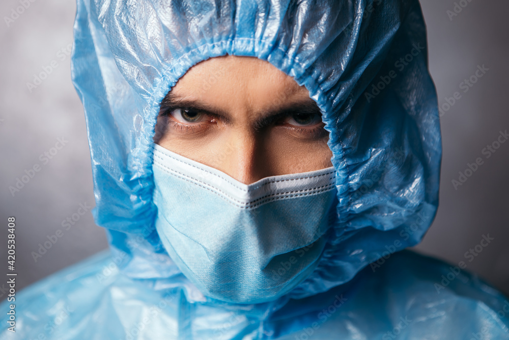 Nurse doctor looking angrily at the camera. Male medic dressed in protective medical suit and blue face surgical mask. Coronavirus concept. Overworked hero health workers
Nurse doctor looking angrily at the camera. Male medic dressed in protective medical suit and blue face surgical mask. Coronavirus concept. Overworked hero health workers