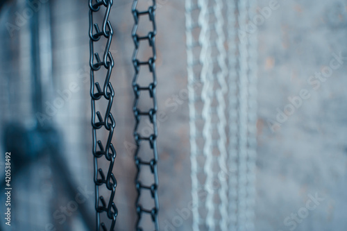 Iron black and white hanging chain on gray background, close-up © Дмитрий Ткачев