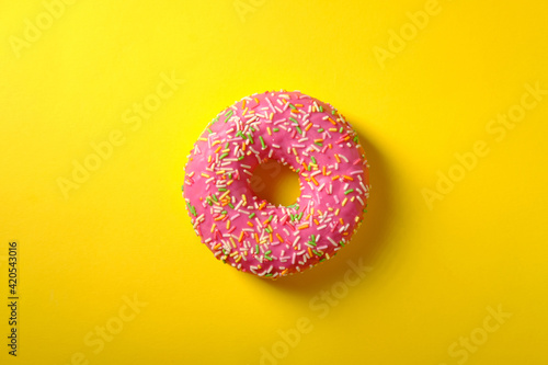 Sweet pink donut on yellow background