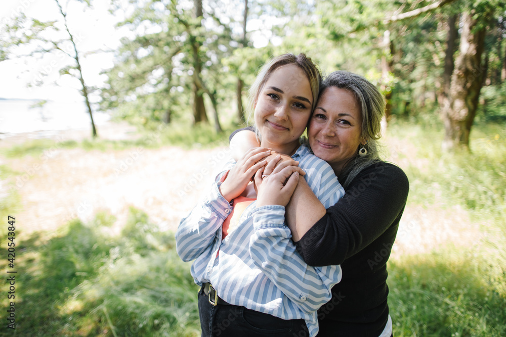 Fun-loving mother and daughter hugging and joking around togethe Fun-loving mother and daughter hugging and joking around togethe