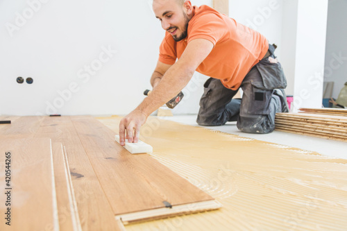 craftsmanr  laying parquet flooring in a modern house