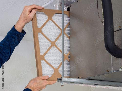 Foto HVAC service technician changing dirty indoor air filter in residential heating and air conditioning system