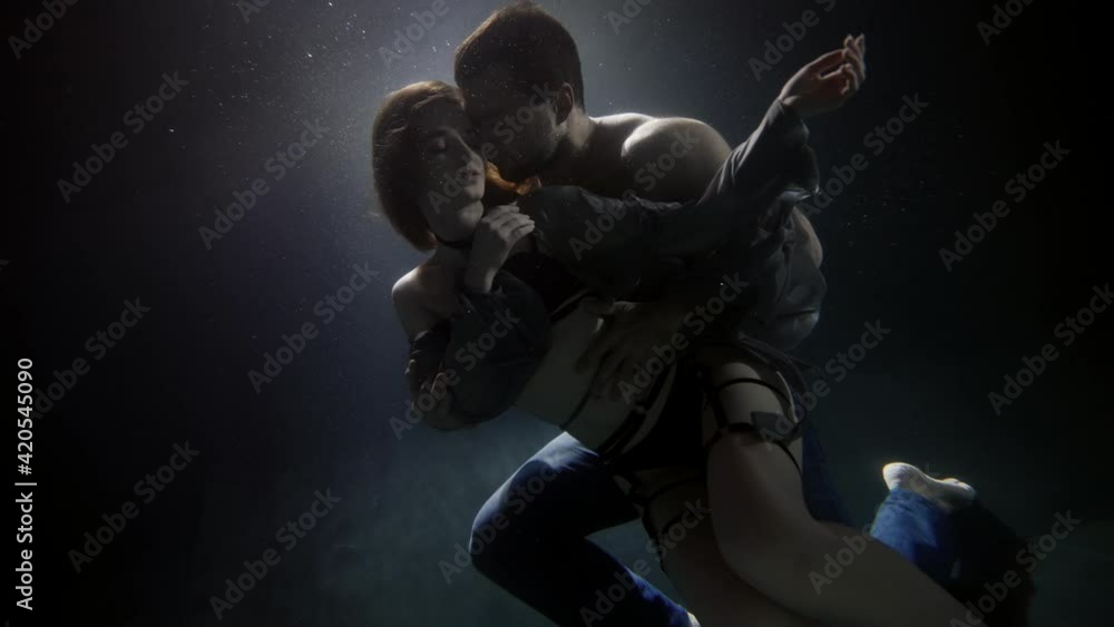 young loving pair is hugging underwater, man is stroking his beautiful girlfriend dressed lingerie young loving pair is hugging underwater, man is stroking his beautiful girlfriend dressed lingerie