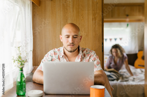 Man working on his laptop in a trailer photo