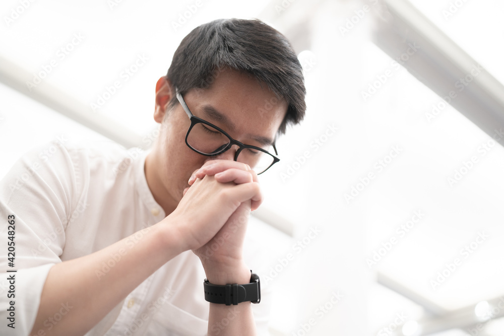 A man praying on a bench in a Christian church. A man praying on a bench in a Christian church.
