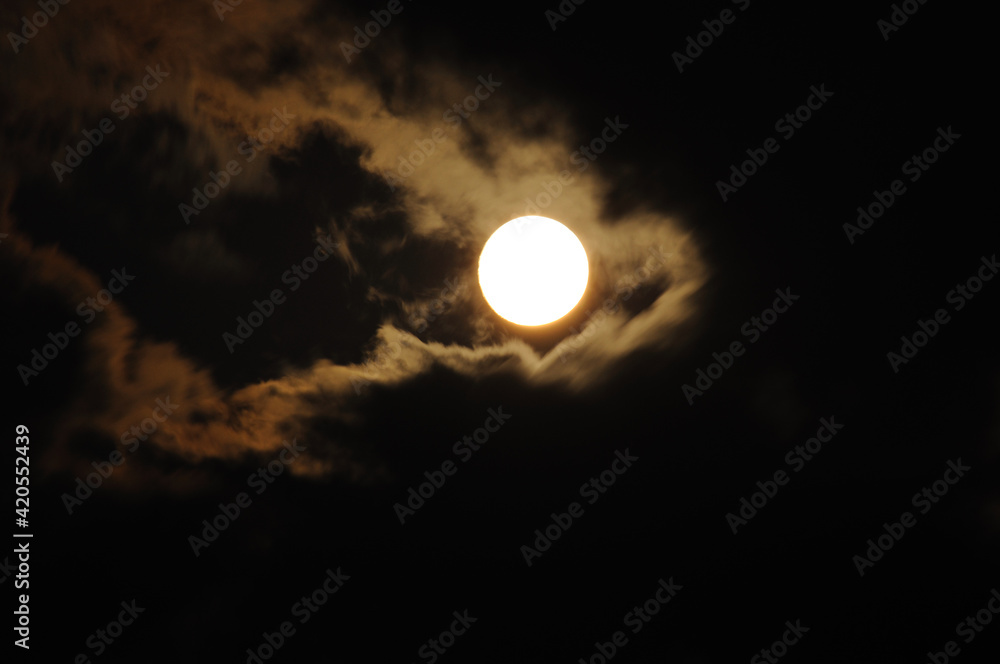 Full moon close-up and eerie white clouds against a black night sky. The big moon on a dark night The clouds gather together in various images. Full moon with dramatic clouds in the night sky. Full moon close-up and eerie white clouds against a black night sky. The big moon on a dark night The clouds gather together in various images. Full moon with dramatic clouds in the night sky.