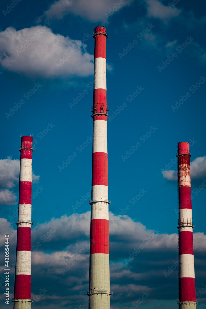 three chimneys on cloudy sky background
