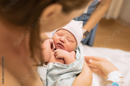фотографія Adorable newborn baby girl sleeping in mothers arms