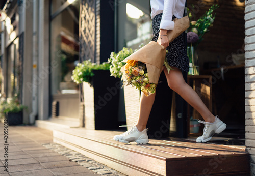 Girl Exiting A Florist Shop With A Bouquet photo