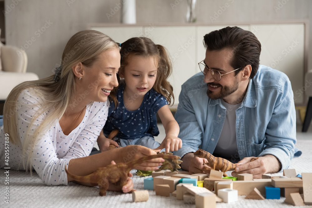 Loving young parents relax with little 7s daughter play wooden blocks bricks and animal toys at home. Happy Caucasian family with small girl child feel playful rest enjoy leisure weekend together. Loving young parents relax with little 7s daughter play wooden blocks bricks and animal toys at home. Happy Caucasian family with small girl child feel playful rest enjoy leisure weekend together.