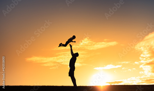 Father throwing his child up in the air playing and having fun outdoors