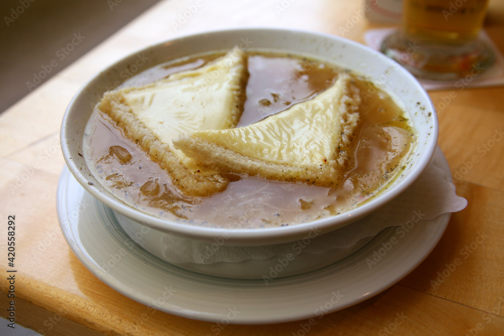 Traditional French onion soup. Croutons with cheese in broth. On a table in a cafe Traditional French onion soup. Croutons with cheese in broth. On a table in a cafe