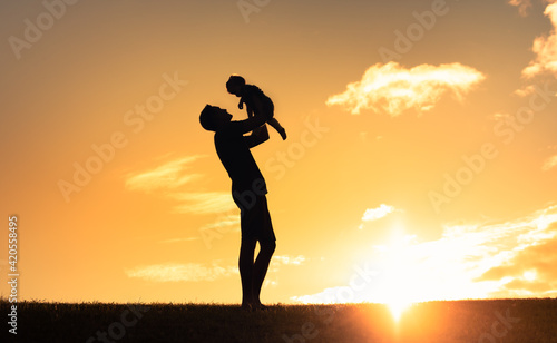 silhouette of father playing with his little child 