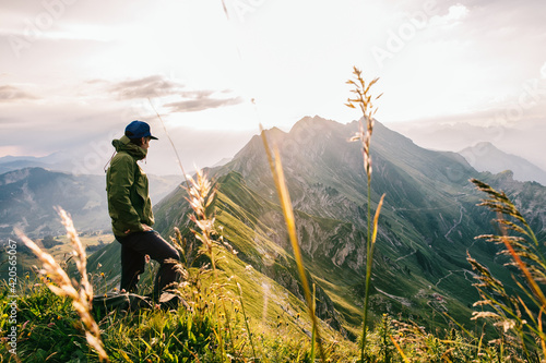 Male Hiker Watching Sunrise in Swiss Mountains photo