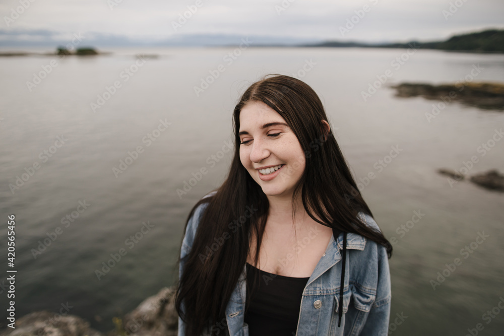 Teenage girl laughing and confident outside near the ocean Teenage girl laughing and confident outside near the ocean