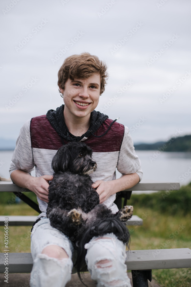Teenager with lap dog on is lap. Teenager with lap dog on is lap.