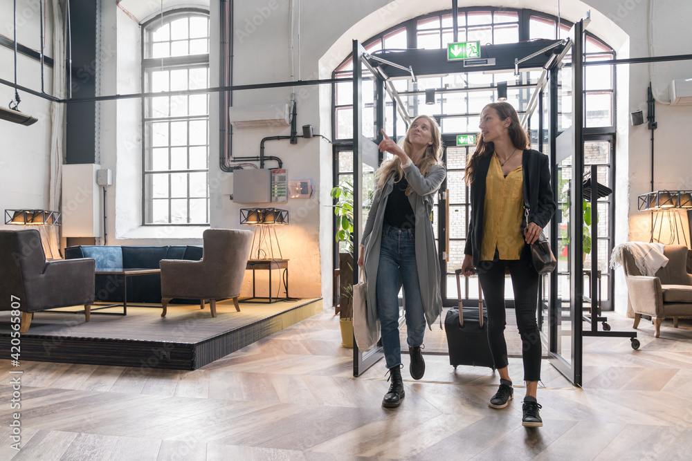 Two Female Entrepreneurs Entering In A Hotel Two Female Entrepreneurs Entering In A Hotel