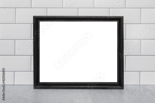 Blank empty white board in a black frame ready to add text or message white subway tile background 