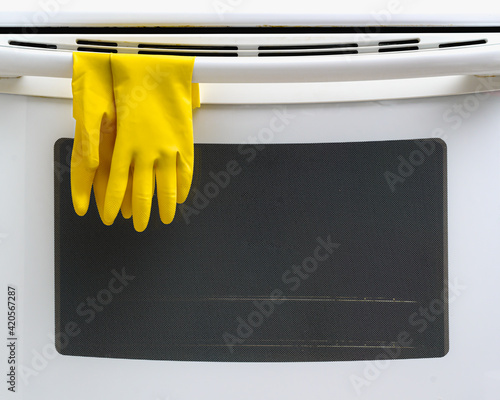 Rubber household cleaning gloves on kitchen stove