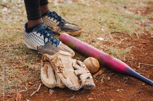 Wall Mural boy with brown skin and latin origin playing baseball in the park with ball, glo