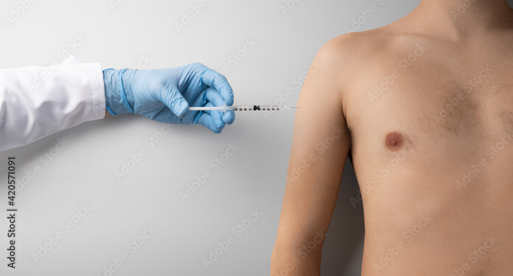 Hand with syringe injection and topless mans torso, covid-19 and vaccination concept. Hand with syringe injection and topless mans torso, covid-19 and vaccination concept.