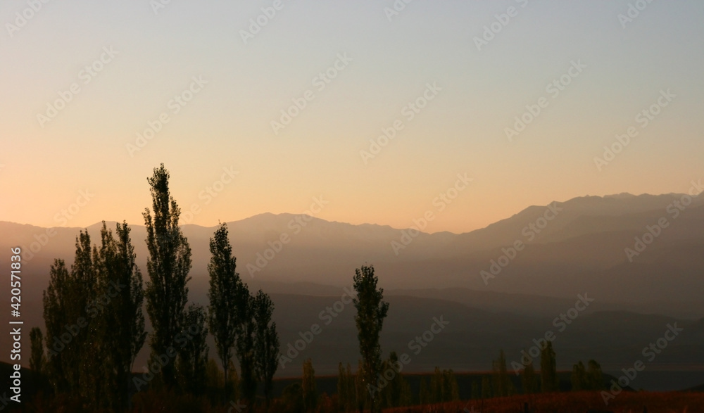 Sunset in the mountains of Kyrgyzstan. A bright orange sunset over sharp black mountains