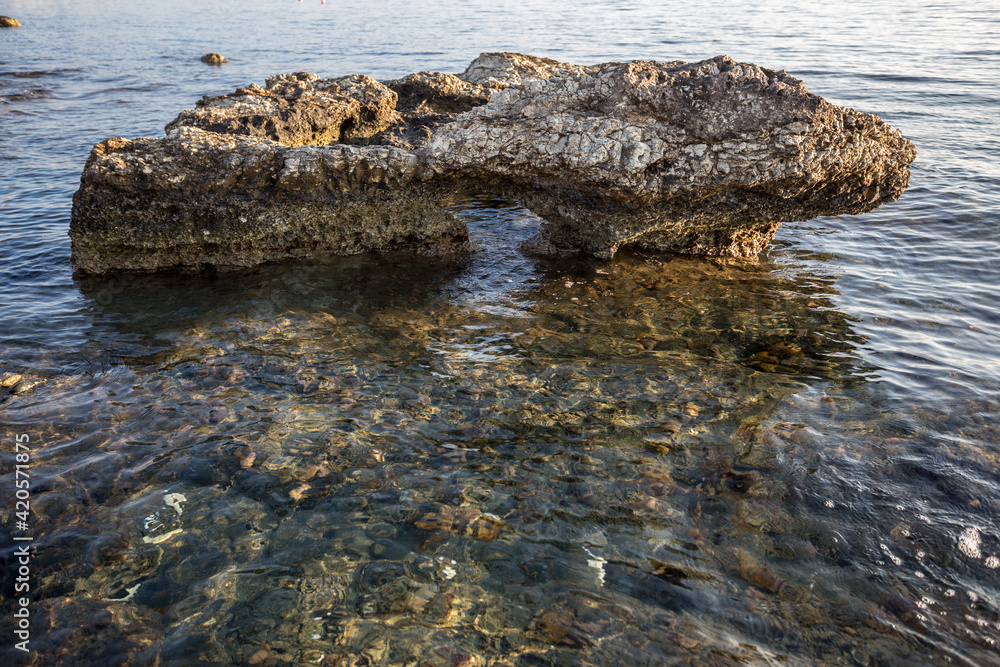 Beautiful Cyprus landscape with a rocky coast. Mediterranean Sea in Cyprus. The rock stands in clear water with an arch. Beautiful Cyprus landscape with a rocky coast. Mediterranean Sea in Cyprus. The rock stands in clear water with an arch.