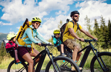 Family with small children cycling outdoors in summer nature, High Tatras in Slovakia.