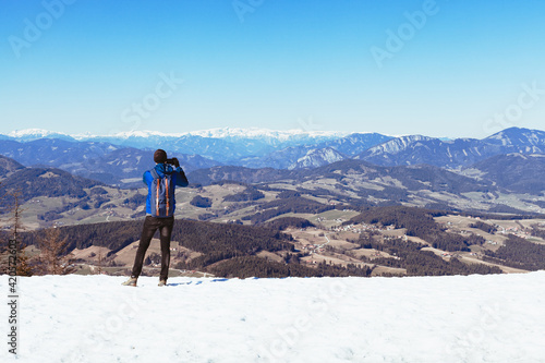 hiker on the top of the mountain takes pictures on his smartphone © edojob