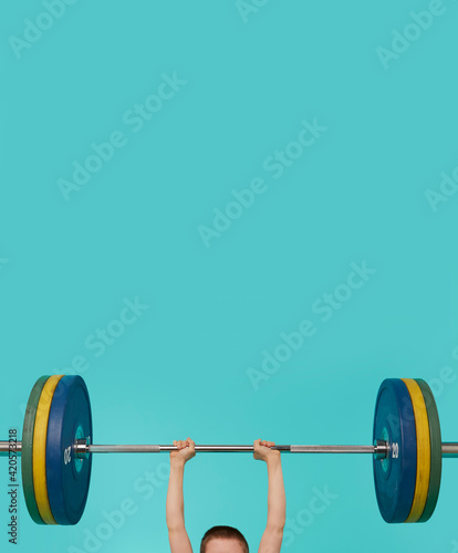 Young child body builder lifts a very heavy barbell
