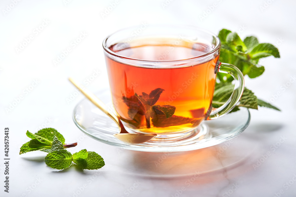 Black tea in glass transparent mug with mint leaves. Soothing tea, anti-stress Black tea in glass transparent mug with mint leaves. Soothing tea, anti-stress