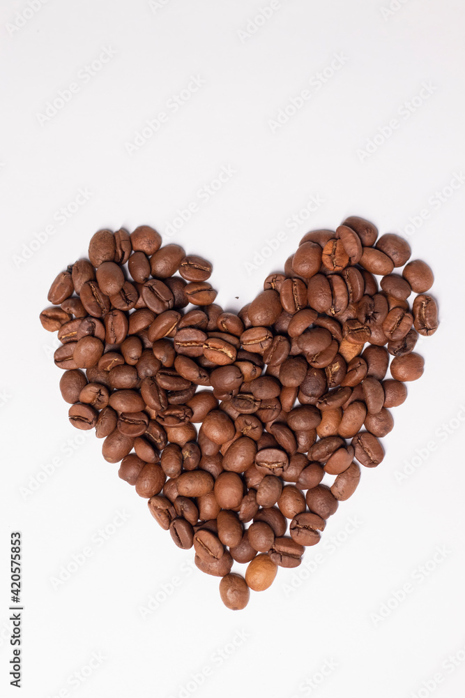 Freshly roasted coffee beans in shape of a heart isolated on white background. top view Freshly roasted coffee beans in shape of a heart isolated on white background. top view