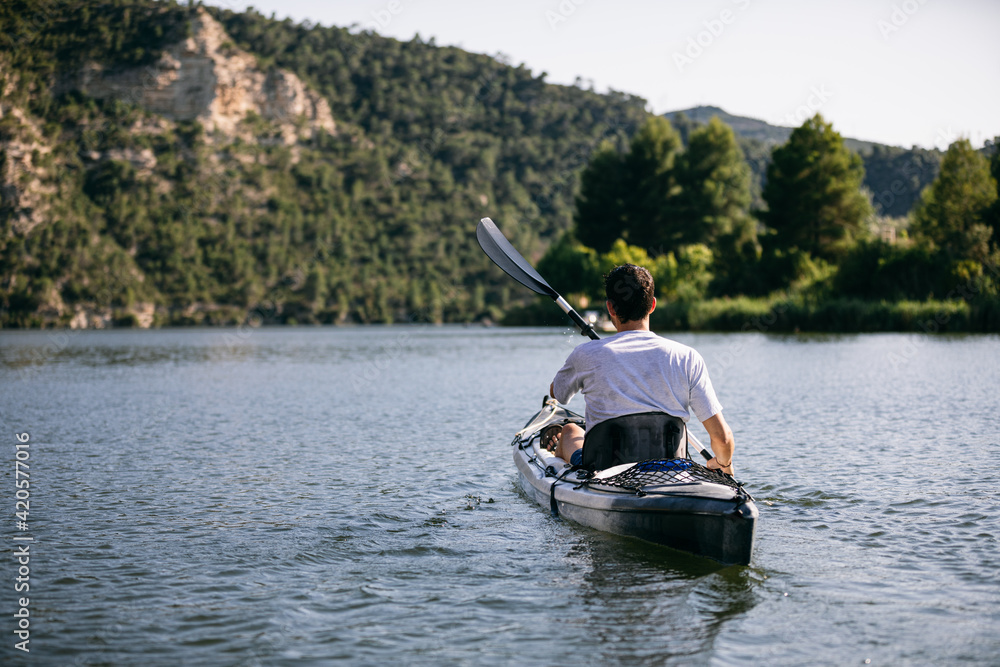 Unrecognizable man kayaking on lake Unrecognizable man kayaking on lake