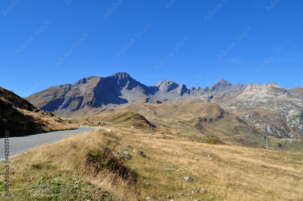 Fototapeta premium High snowy mountains with dry autumn grass and blue sky in France