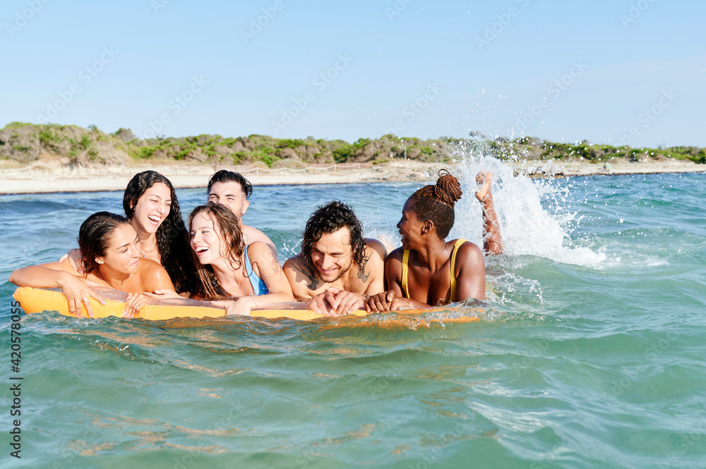 Friends sitting on a float in the ocean Friends sitting on a float in the ocean