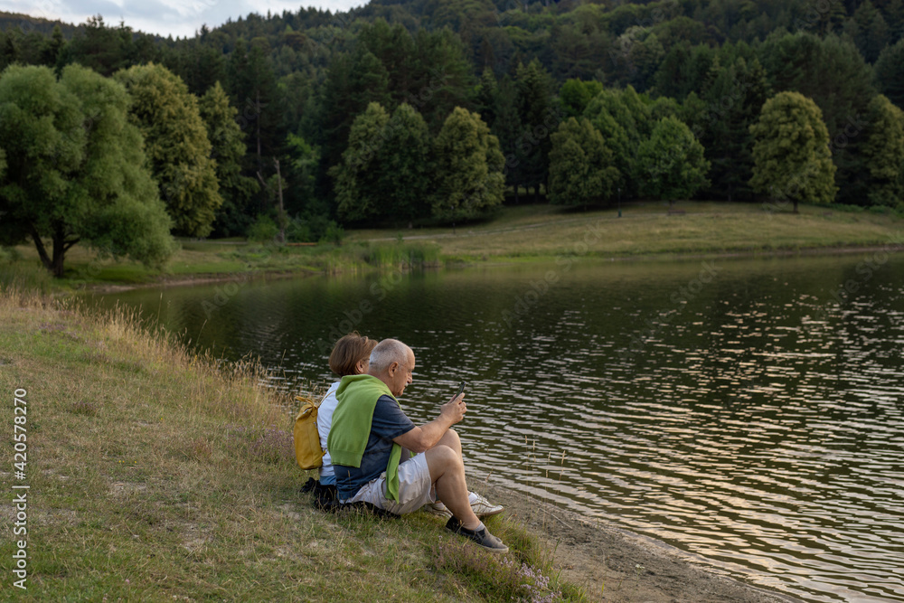 Senior couple enjoying together by the lake Senior couple enjoying together by the lake