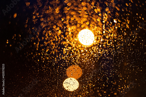 Background image of a night lantern through the glass on a rainy night