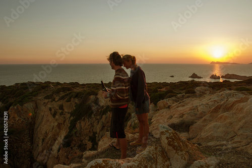 Young Couple at sunset on top of a cliff. photo