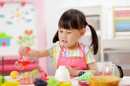 young girl pretend play food preparing at home