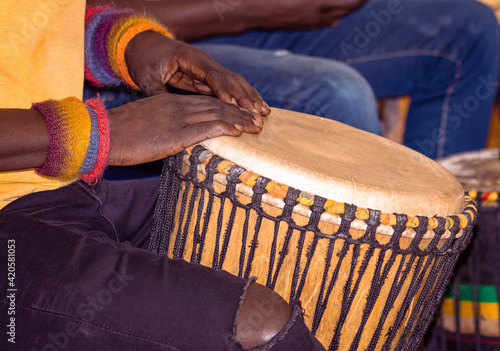 Close up of an African djembe drummer. Drummer playing African percussion music. Ethnic percussion musical instrument Djembe and male hands. Rhythm of Africa.

