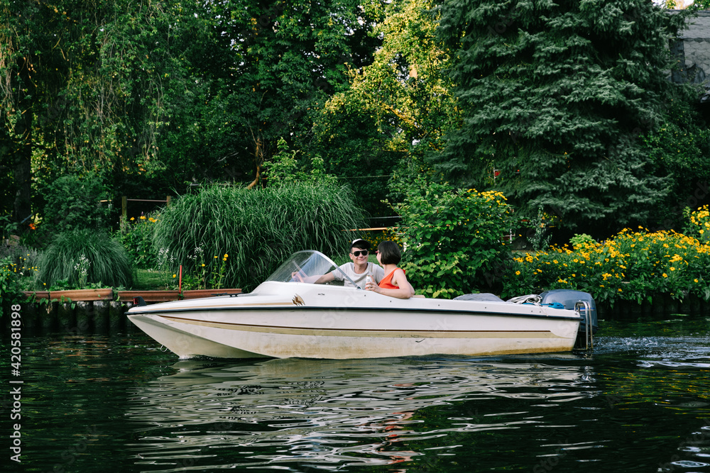 Couple Driving Small Boat In Warm Evening Light Couple Driving Small Boat In Warm Evening Light