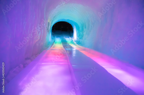 Fototapeta Naklejka Na Ścianę i Meble -  Ice slide in a tunnel with rainbow colors