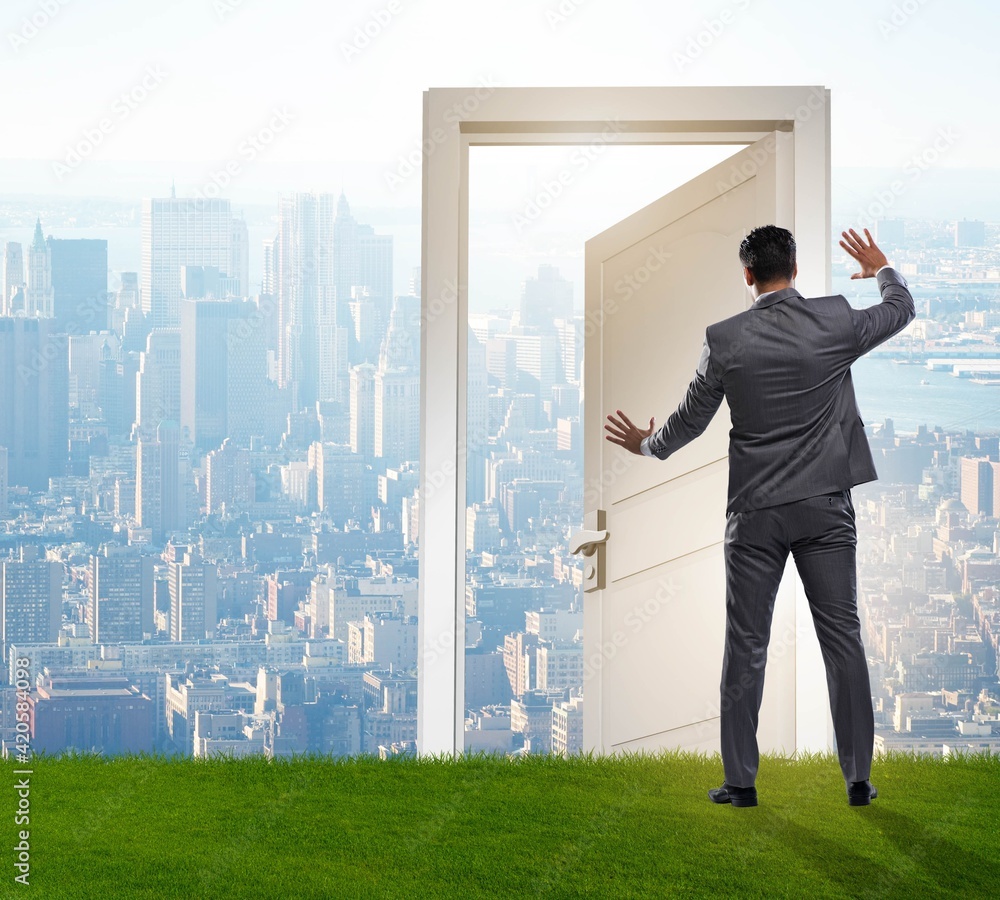 Businessman standing in front of door into future Businessman standing in front of door into future