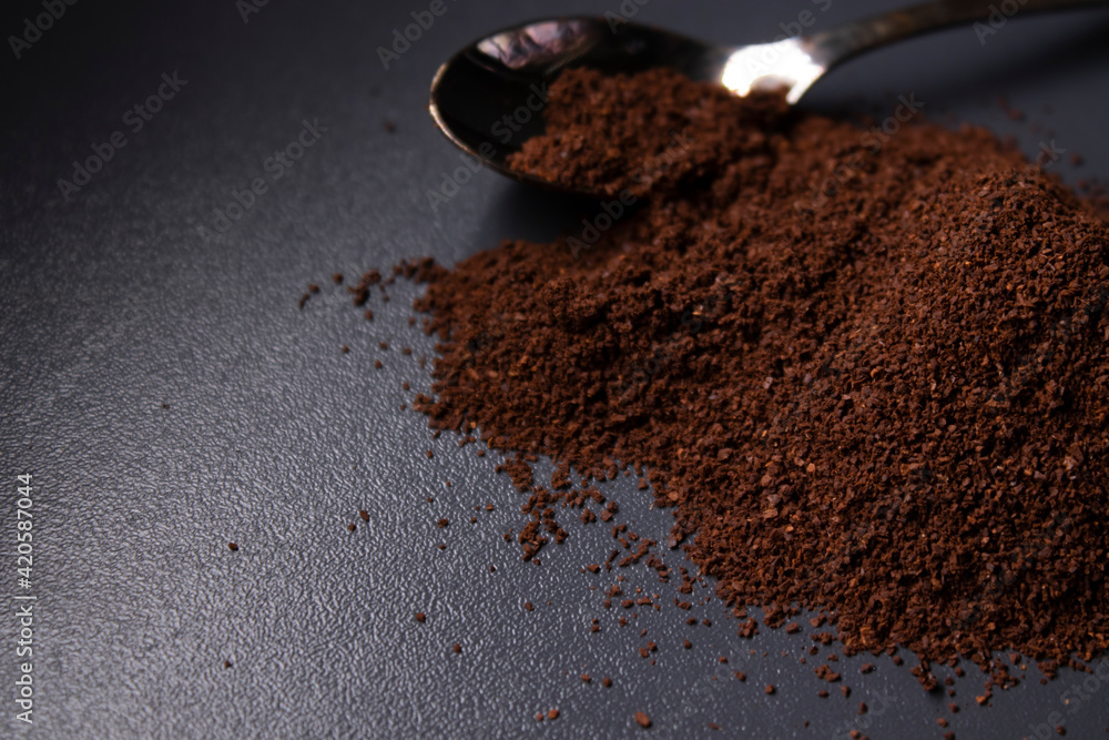 gold teaspoon in a pile of ground or instant coffee on dark background gold teaspoon in a pile of ground or instant coffee on dark background