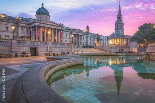 A vibrant colourful, dramatic sunrise or sunset sky at Trafalgar Square and the National Gallery in central London, UK.