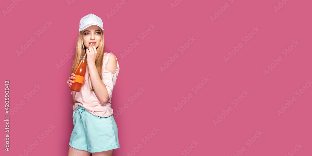 Sporty woman with cold drink standing on pink background Sporty woman with cold drink standing on pink background