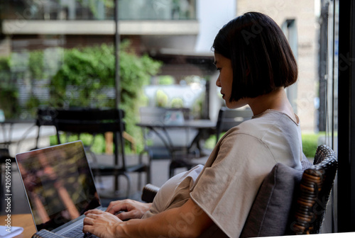 Pregnant woman working on a computer from outdoor co-working space