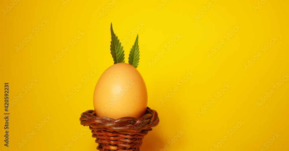 Bunny made of Cannabis leaves. Easter egg. Yellow background.   - obrazy, fototapety, plakaty 