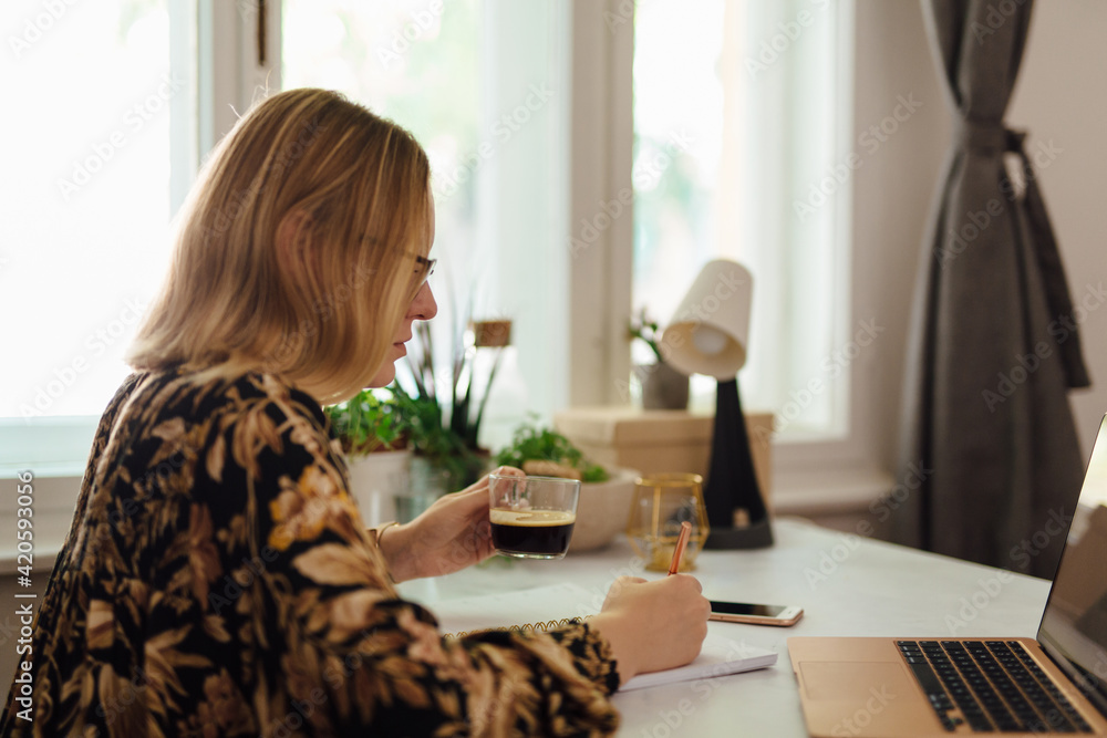 Young Woman Drinking Coffee And Writing In Her Notebook Young Woman Drinking Coffee And Writing In Her Notebook